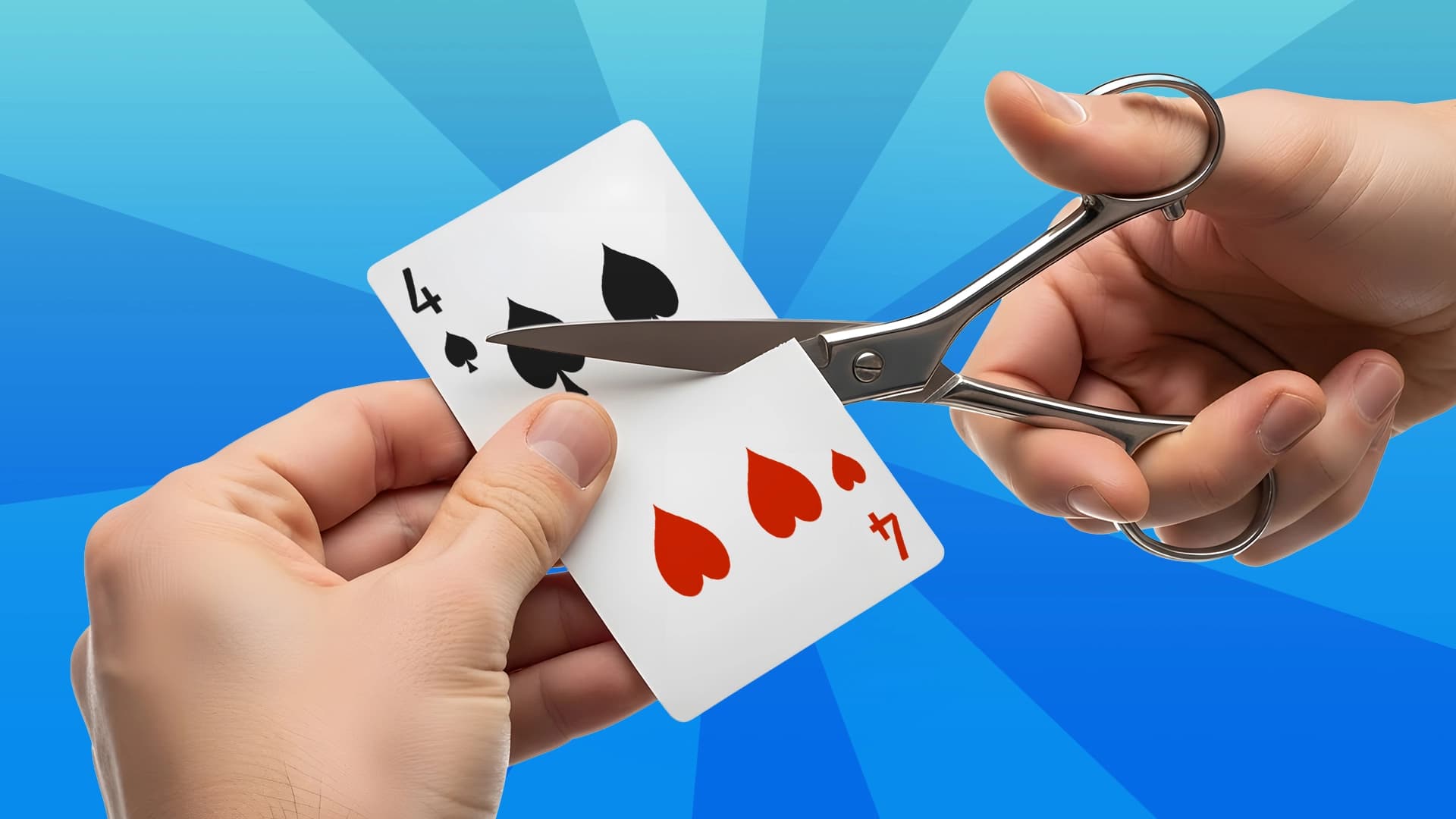 Scissors cut a playing card showing black and red 4 of spades and hearts.