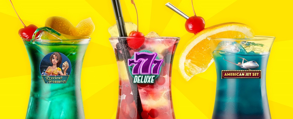 Three summer cocktails stand against a yellow backdrop. The left green drink is garnished with a cherry and orange peel, and a Cafe Casino slots game logo for Precious Treasures. The central red berry cocktail is features ice and berries and a neon Cafe Casino 777 Deluxe logo. The right turquoise cocktail, with an orange wedge, cherry and silver straw, features an American Jet Set Hot Drop Jackpots logo.