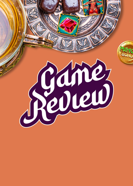 Featured in the middle of the image are the words “game review”, in purple and white font. Above, chocolates sit on a brass plate along with two partially obscured symbols from the Cafe Casino slot game, Oasis Dreams Hot Drop Jackpots.
