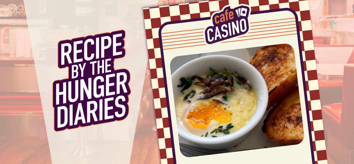 Eggs en Cocotte in a small bowl, with toasted bread on the right side, is visible on an old-school-style Cafe Casino menu. An American diner is visible in the background. Overlaid text “Recipe By The Hunger Diaries” is on the left of the image.