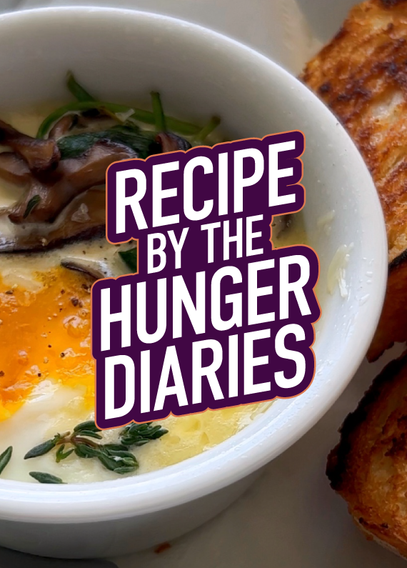 Baked eggs in a bowl with spinach and thyme; toasted bread visible on the side of the bowl; overlaid with the words “Recipe By The Hunger Diaries” in purple font.