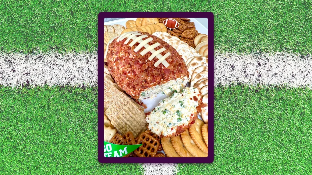 A platter featuring a football shaped cheese ball is in the middle of a framed image, surrounded by an astroturf background.