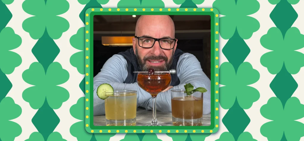 John Rondi leans behind three cocktail glasses of varying heights, on a green shamrock background.